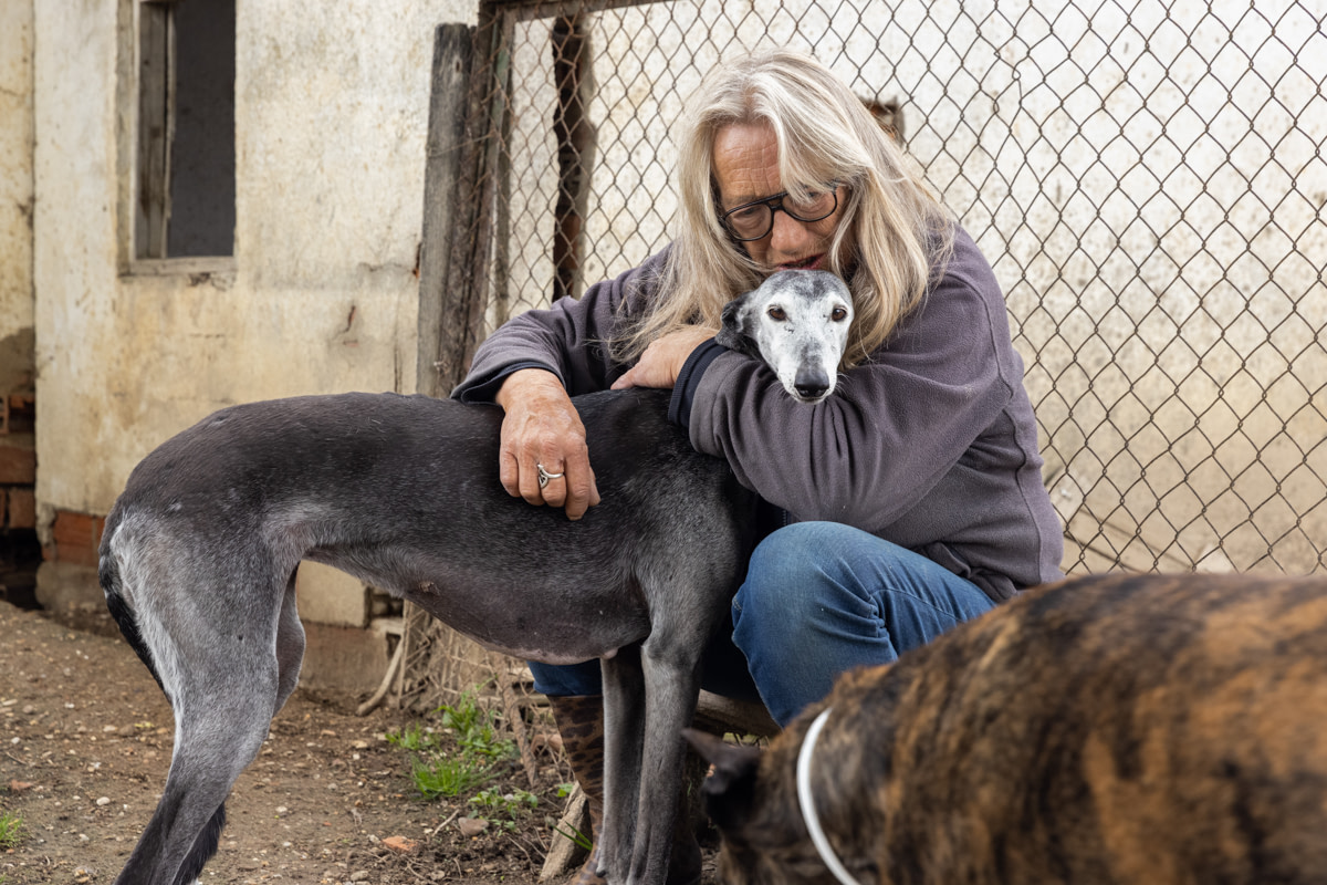 Cobie Steketee, the director of this shelter, hugs Rhea one of the five dogs she has adopted herself. Spain, 2021. Ana Palacios / We Animals