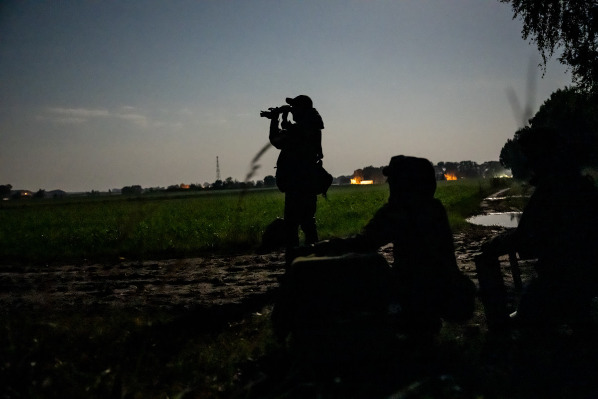 Investigators use optical aids as they approach a fur farm in the early hours of the morning, where hundreds of foxes and raccoon dogs are kept. Poland, 2024. Jo-Anne McArthur / Anima International / We Animals