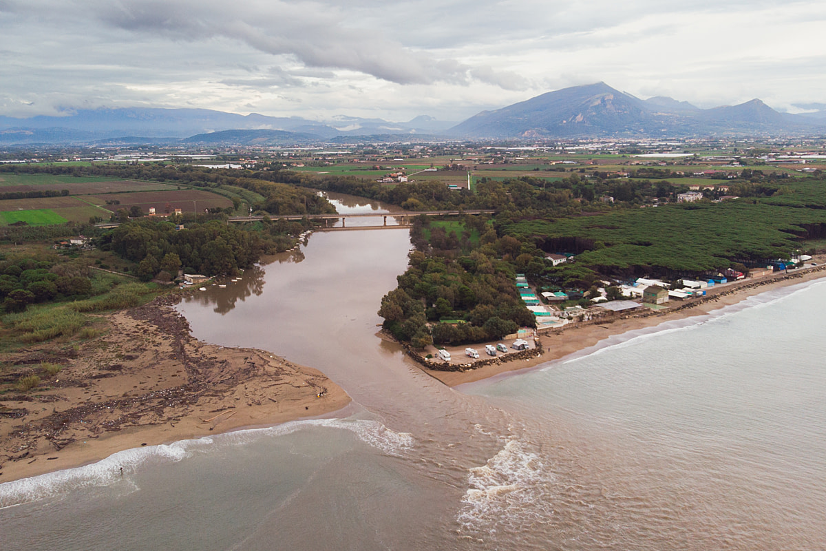 An aerial view of murky brown water flowing through agricultural land and out the mouth of the Sele River into the Gulf of Salerno in the Tyrrhenian Sea. According to local residents, effluent from intensive buffalo dairy farms enters neighboring rivers, most noticeably during rainfall. Eboli, Salerno, Italy, 2024. Raffaele Petralla / We Animals