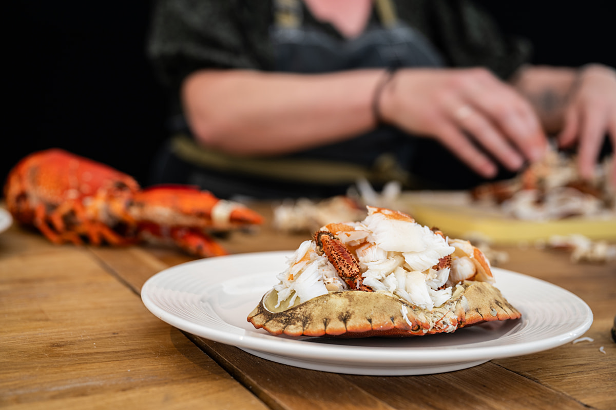 The body of a dead and partially dismembered cooked crab lies on a plate during a seafood festival cooking demonstration. Bridlington Seafood Festival, Bridlington, East Yorkshire, England, UK, 2024. Amy Jones / Viva! / We Animals