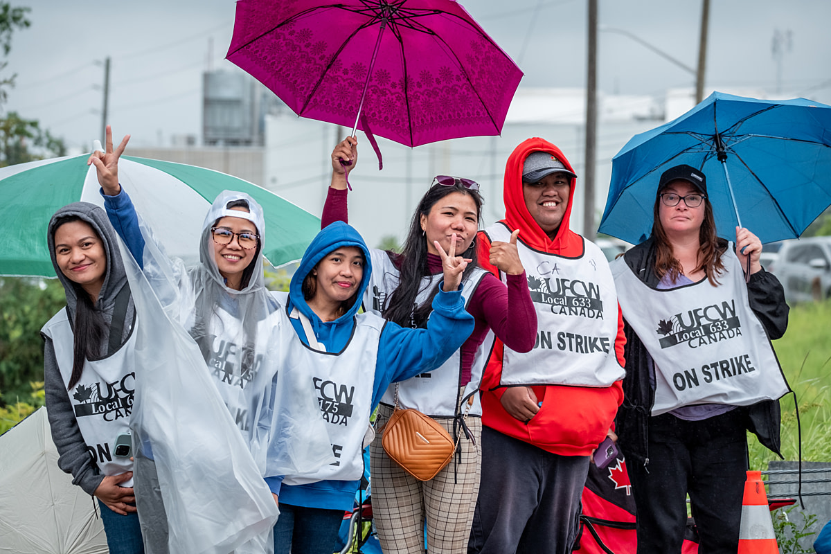 Workers from a Cargill, Inc. cattle slaughterhouse gesture and smile while picketing during a strike for better wages and conditions at the facility. Guelph, Ontario, Canada, 2024. Ira Moon / We Animals