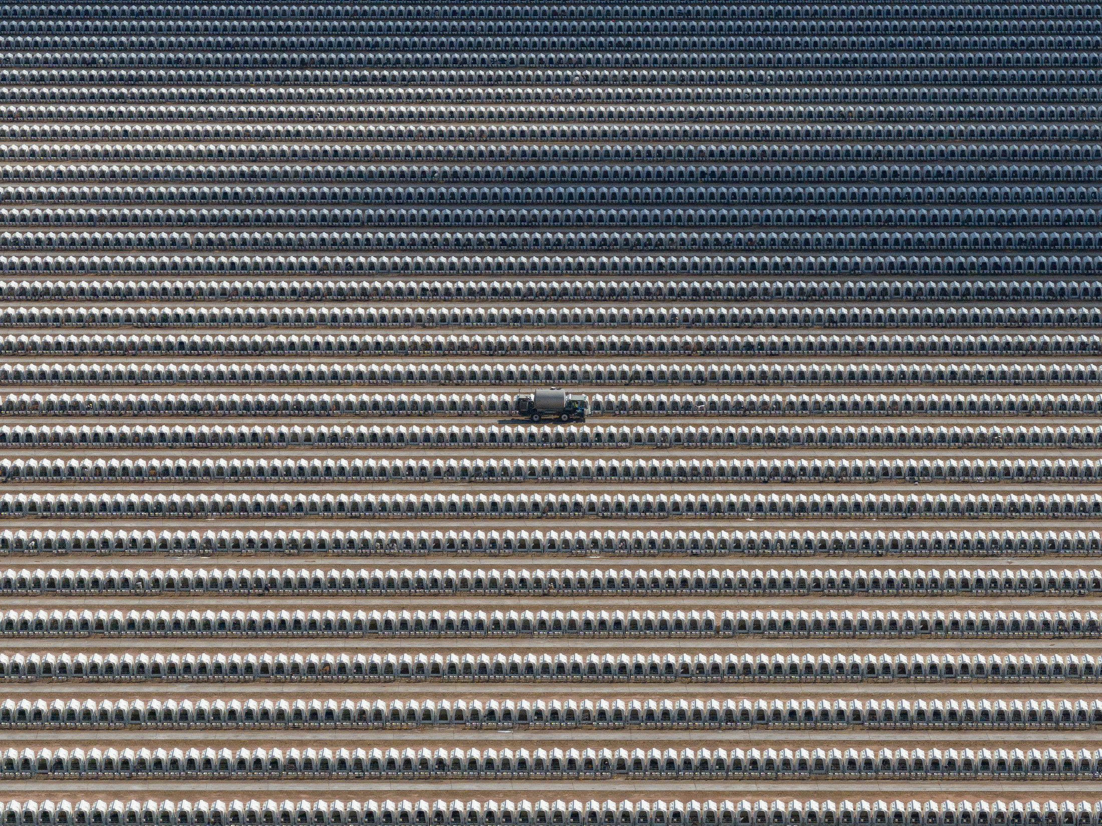 A milk dispenser truck drives between some of the thousands of calf hutches in a massive dairy farm's yard. Turkey Creek Dairy, Pearce, Arizona, USA, 2023. Ram Daya / We Animals Media