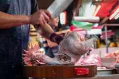 Chicken carcass is chopped into parts before sale at a wet market in Taipei. Taiwan, 2019.