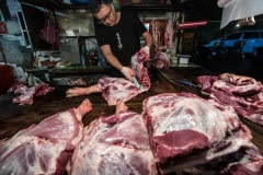 Vendor chops pig legs at a wet market in Taipei. Taiwan, 2019.