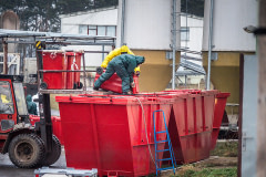 Dead hens are emptied into a large dumpster by workers outside the barns at an egg farm near Prague in Czechia. Workers wearing protective suits are killing and removing the hens from this farm, where an outbreak of the H5N1 bird flu virus has been detected.  Czechia, 2021. Lukas Vincour / Zvířata Nejíme / We Animals