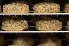 Racks of cultured, organic, cashew milk artisan cheese wheels at Miyoko's Creamery.