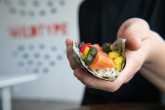 Chef Jun Sog holds a sushi roll at Wildtype's test kitchen, a company that grows cell-cultivated salmon.