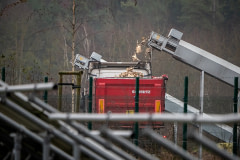 On a Czech industrial egg farm during an avian influenza outbreak, dead hens fall from a conveyor into a heap inside a transport container after being killed in a mass culling operation. Czechia, 2023. Lukas Vincour / Zvirata Nejime / We Animals