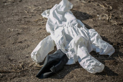 Used biosecurity coveralls lie on the ground during a mass culling of turkeys at an Israeli kibbutz. Israel, 2016. Glass Walls / We Animals