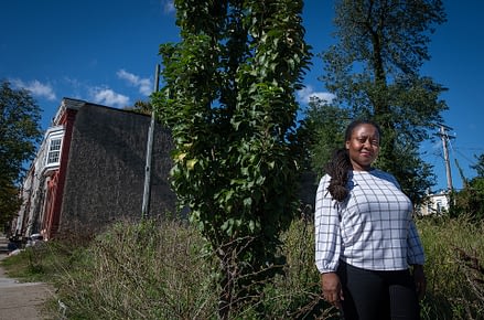 Brenda Sanders with one of the remaining apple trees that was planted as part of her initiative to create community gardening spaces in Baltimore. Photo by: Jo-Anne McArthur / #UnboundProject / We Animals Media.
