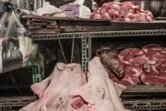 Skinned pig faces are hooked and hung for display at a meat stall in a Taipei wet market. Taiwan, 2019.