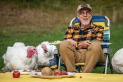 Tofurky founder Seth Tibbott and rescued turkeys enjoy a meal and each other's company at Wildwood Farm Sanctuary & Preserve.
