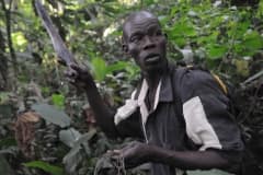Dominic holding a snare and a machete in the Budongo Forest. Uganda, 2009.