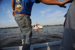 The US Coast Guard checks all boats and their drivers for permits, who aren't supposed to take media out to document the spill. Though our driver had a permit, the Coast Guard kept an eye on us until we were back in port. Louisiana, USA, 2010.