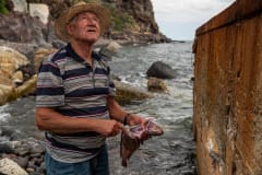 Fisherman demonstrating fish slaughter to tourists.