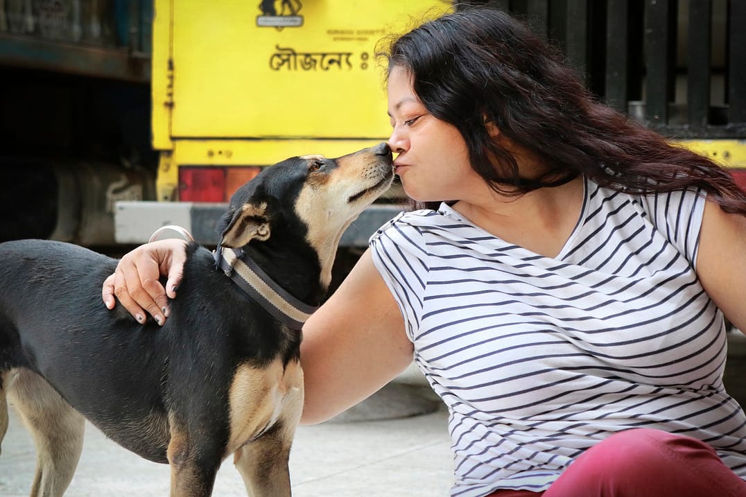 Rubaiya Ahmad with one of the free-roaming dogs that Obhoyaronno treats