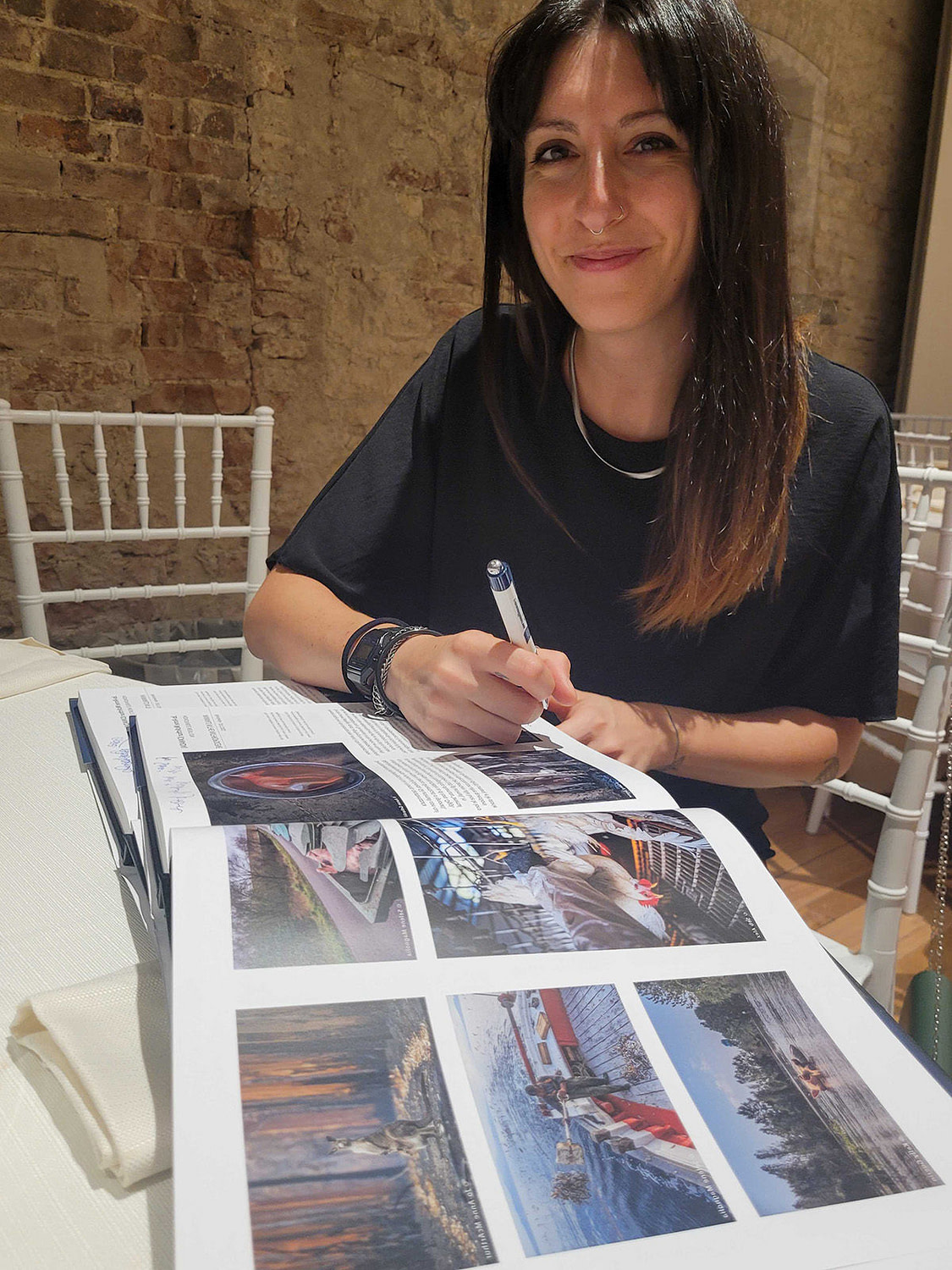 WAM's Senior Fellow Selene Magnolia signing the SIPA 2023 'Beyond the Lens' photo book.