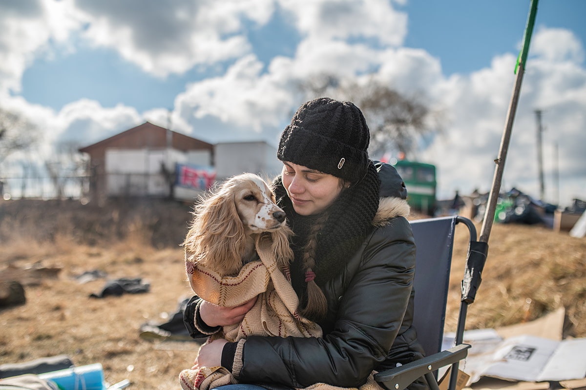 Ukrainian refugee Anastasia sits with her dog after finally crossing the Polish Ukrainian border in Medyka, Poland.Fleeing from an area of Kyiv devastated by Russian bombing, Anastasia left her mother and brother in Lviv and traveled to the border accompanied only by her dog. She will continue on to Germany where she will stay on the farm of a kind stranger who offered to take her in. Once there, she plans to put her skills as an English professor to use by offering English lessons to other displaced Ukrainians.