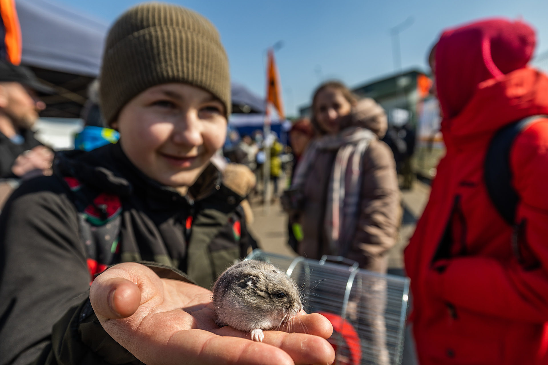 A young Ukrainian refugee holds out his pet hamster at the Medyka border crossing in Poland.