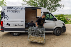UAnimals team member Vlad carries a dog crate that will transport German Shepherd Karat, a rescued dog being evacuated to his new family in another location.