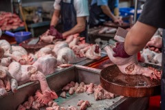 Chicken carcasses are chopped into parts before sale at a wet market in Taipei. Taiwan, 2019.