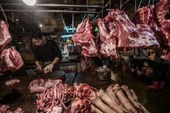 Pig carcasses are chopped and hung for sale display at a Taipei wet market. Taiwan, 2019.
