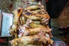 Pig feet are burned and scraped to remove hair at a wet market in Taipei. Taiwan, 2019.