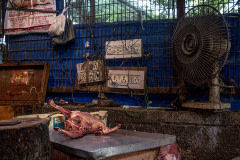 The skinned body of a chicken is seen on a butcher's table, waiting to be cut, in a local meat market. India, 2021. S. Chakrabarti / We Animals Media