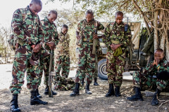 NPR (National Police Reservists) have a moment of prayer before they go out on an overnight patrol of Ol Pejeta Conservancy in Central Kenya. The armed men patrol the 360 km2 (140 sq mi) not-for-profit wildlife conservancy around the clock and protect the rhinos and other animals from deadly poachers. Kenya, 2019. Justin Mott / Kindred Guardians Project / We Animals Media