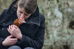 Lina Lind Christensen with a rescued hen at Frie Vinger. Translated as Free Wings, Frie Vinger is a sanctuary that rescues and re-homes battery hens from the egg industry. Denmark, 2015.  Jo-Anne McArthur / #unboundproject / We Animals Media
