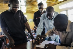 Villagers sign a document (ink on thumb, to paper) saying that they will give up poaching. Uganda, 2009.