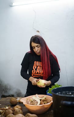 Activist Azul Cardozo prepares vegetables for a stew. Every Saturday afternoon, Azul collaborates with a project that cooks popular vegan dishes for low-income people in Uruguay. Photo Credit: Martina Victoria Zamudio / We Animals Media