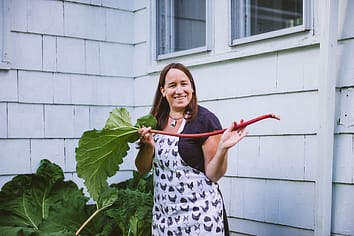 Hannah Murray proudly holds up a stalk of rhubarb harvested from her garden. She will be making blueberry-rhubarb pie for dessert tonight. Photo by Victoria de Martigny / #unboundproject / We Animals Media