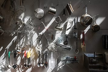 A wall of kitchen utensils at Baltimore's vegan restaurant The Greener Kitchen. Photo by: Jo-Anne McArthur / #UnboundProject / We Animals Media.