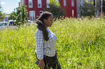 Activist Brenda Sanders walks through what was once a thriving community garden in Baltimore. Despite a public outcry, the city reclaimed the space. Photo by: Jo-Anne McArthur / #UnboundProject / We Animals Media.