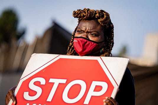 Gwenna Hunter stands outside a meat packing plant in silent protest during a cow vigil. Photo by Nikki Ritcher / #unboundproject / We Animals Media.