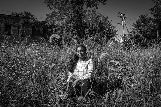 Activist Brenda Sanders crouches in what was once a thriving community garden in Baltimore. Despite a public outcry, the city reclaimed the space. Photo by: Jo-Anne McArthur / #UnboundProject / We Animals Media.