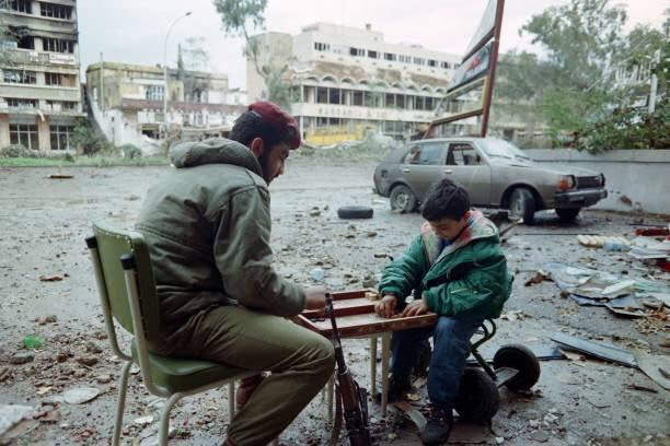 Lebanese Forces fighter playing backgammon with a kid in the late 1980s. Photo source: reddit.com, credit unknown